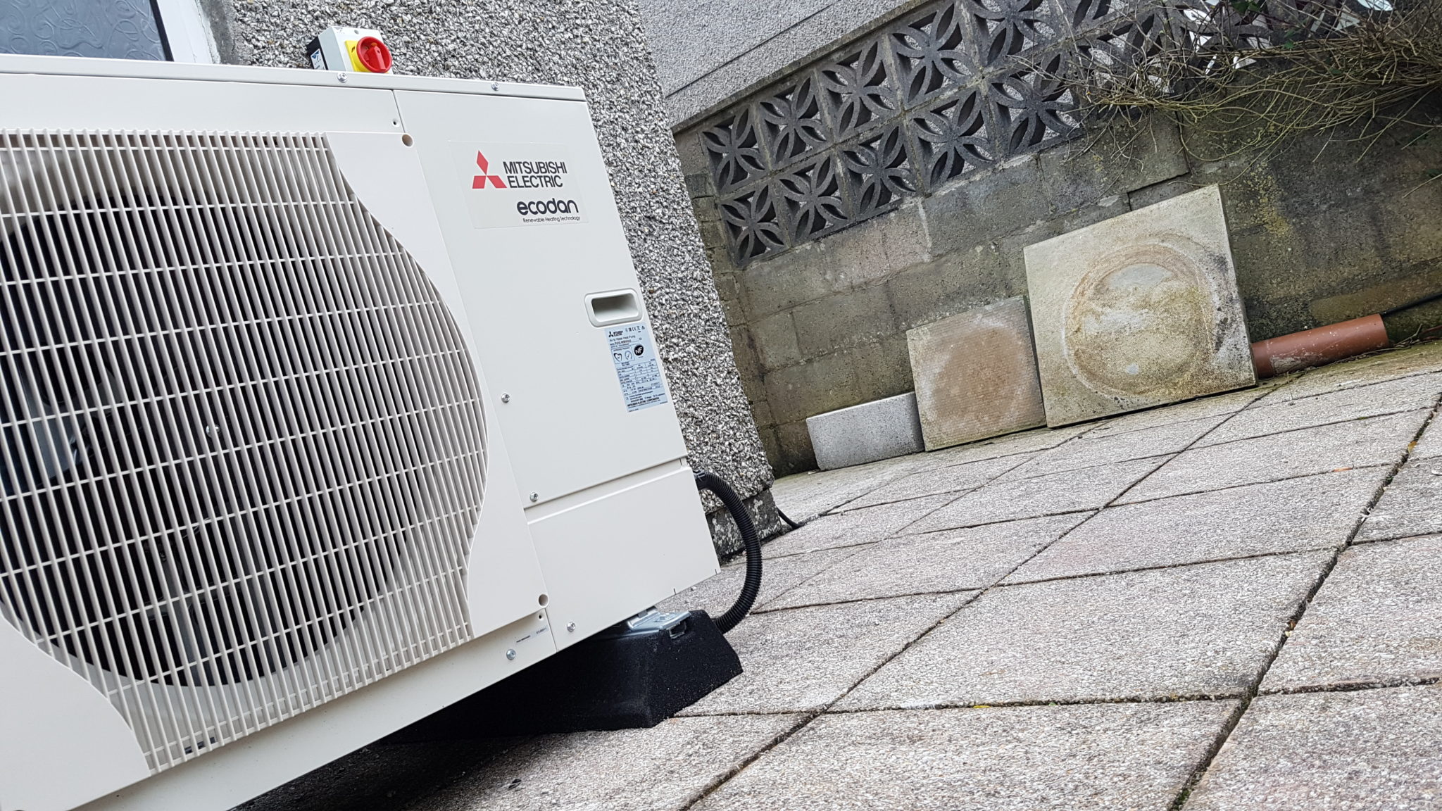 A 5kW air source heat pump unit installed on the external wall of this property in The Lizard.,